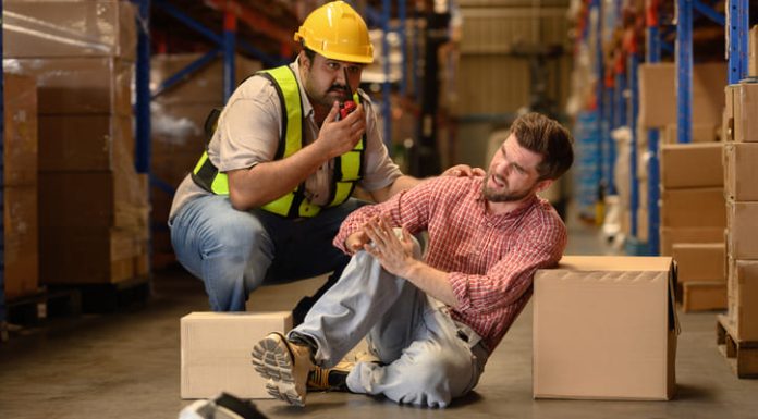 Worker handling large cardboard boxes then some of the box falling and hit by accident