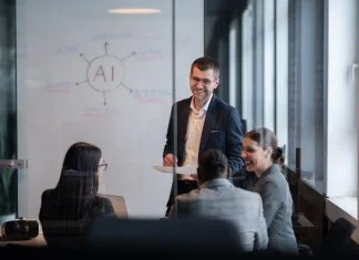 6 Ways to Lead Reinvention in the Workplace Diverse business team in a modern office during a meeting, discussing artificial intelligence and Reinvention strategy. Concept of AI innovation, teamwork, leadership, corporate planning, professional collaboration