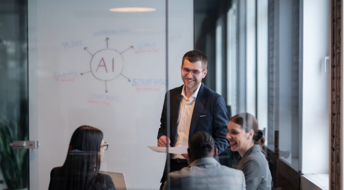 6 Ways to Lead Reinvention in the Workplace Diverse business team in a modern office during a meeting, discussing artificial intelligence and Reinvention strategy. Concept of AI innovation, teamwork, leadership, corporate planning, professional collaboration