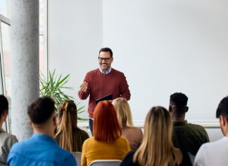 The Science Behind Positive Affirmations in Leadership Coaching Corporate speaker delivering a motivating training about affirmation to a group of diverse employees.