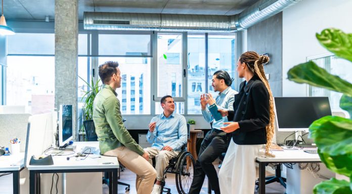 Business team discussing ideas, reputation equity in modern office with disabled colleague