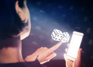 Image of a girl with a smartphone in hands. She presses on the dice icon. Concept of entertainment and iGaming