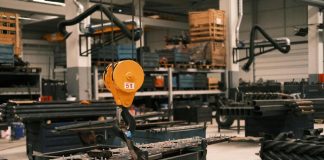 A huge crane lifting heavy equipment indoors