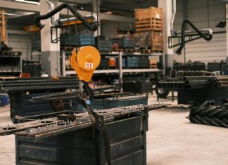 A huge crane lifting heavy equipment indoors