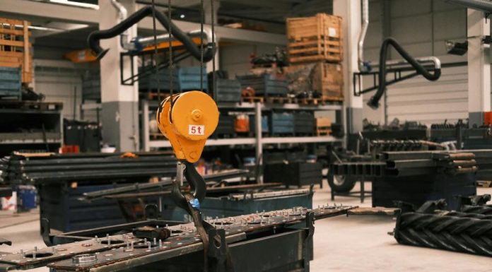 A huge crane lifting heavy equipment indoors