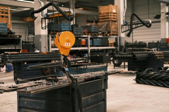 A huge crane lifting heavy equipment indoors