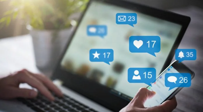 Like, share and post on social media. Hands holding smartphone with social media network icons.