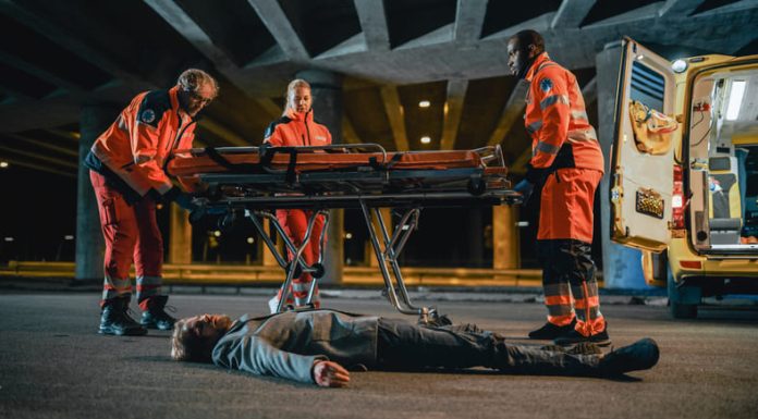 Emergency Care Assistants Arrived on the Scene of a Traffic Car Accident on a Street at Night.