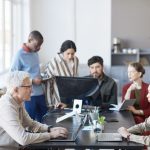Show Your Age: How to Combat Ageism and Reinvent the Workforce co-workers of all ages working at the office. Ageism in the workplace concept
