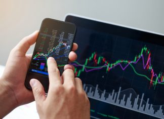 Businessman hand holding phone and analysis finance market graph stock market trading, stock chart and investment