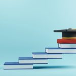 wooden people sign and graduation cap for MBA on book stairs