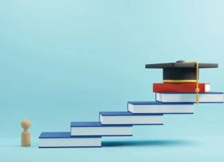 wooden people sign and graduation cap for MBA on book stairs