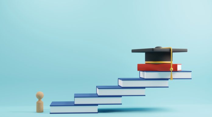 wooden people sign and graduation cap for MBA on book stairs