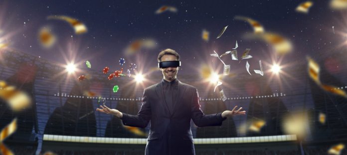 Handsome businessman in VR glasses standing on 3D sport arena with many chips, tokens. Online game.