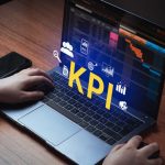 Beyond Traditional Business KPIs: How Modern Financial Metrics Drive Digital Transformation Woman use laptop with KPI holographic interface on screen.