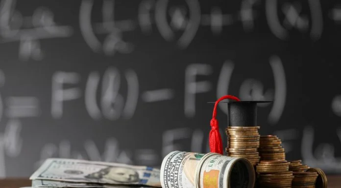 Coins, MBA ROI, dollar banknotes and graduation cap on wooden table