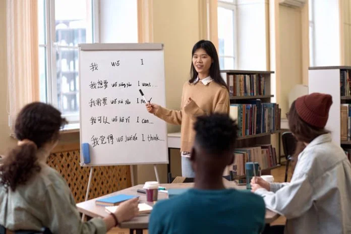 Portrait of young Asian woman teaching Chinese language to a group of employees