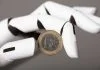 AI bot holding Euro coin. AI in Europe concept