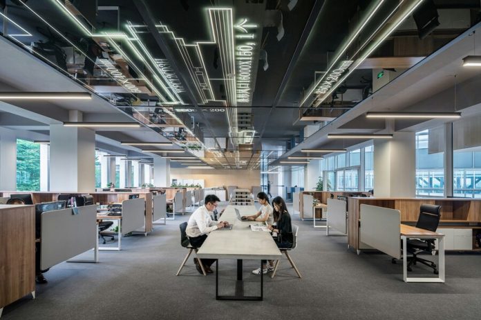 man and woman sitting on table in the office