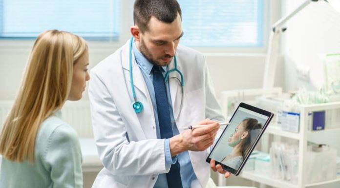 Plastic / Cosmetic Surgeon Consults Woman about Facial Lift Surgery, He Draws Arrows on Digital Tablet Computer Screen, Showing Types of Facelift, Forehead Correcting Procedures Available for Her.