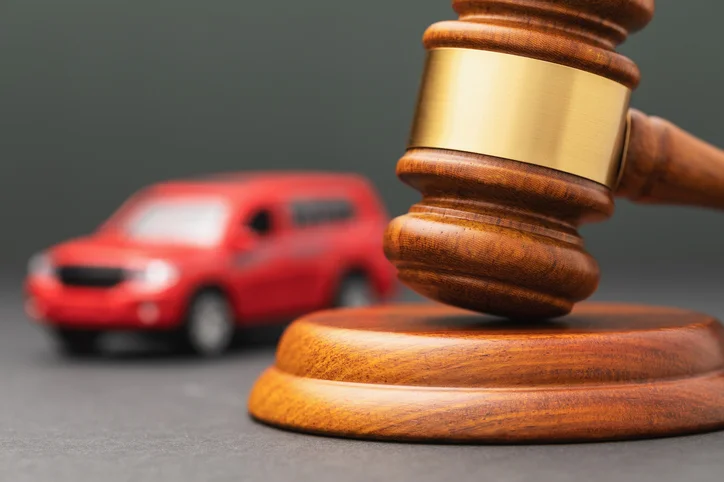 The toy car and the judge gavel are on the table for personal injury concept