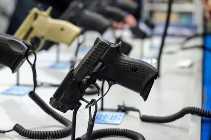 Handgun store shelves. A handgun for sale in the store. Buying a Gun