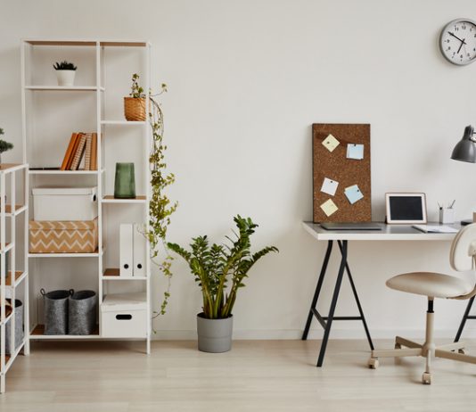 Minimal background image of cozy home office workplace in white tones decorated with green plants, copy space