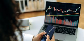 From Beginners to Pros: A Flexible Trading Journey with WeMasterTrade Investment, trading in the stock market. The girl uses a phone and a laptop, looks through the stock market, analyzes stocks, a stock trader assesses risks and possible profits, develops a strategy