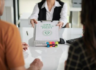 Agent giving life insurance policy to young couple after discussing ULIP
