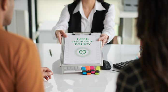 Agent giving life insurance policy to young couple after discussing ULIP