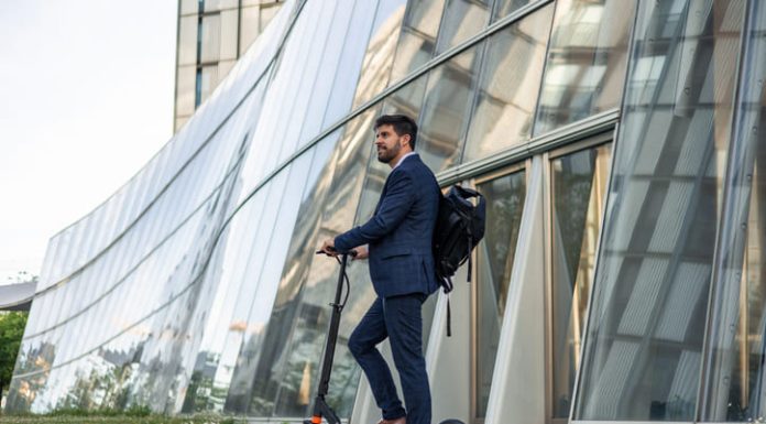 Smart mobility in the workplace. Businessman riding an electric vehicle going home after work
