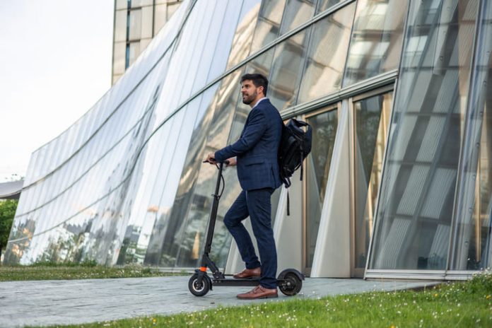 Smart mobility in the workplace. Businessman riding an electric vehicle going home after work