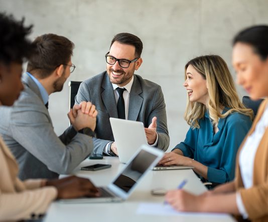 The Most Misunderstood Skill in Leadership: What Emotional Intelligence Really Looks Like in Action Businessman with emotional intelligence together with successful multiethnic business people working on teamwork meeting in corporate office.