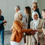 A group of diverse professionals happily exchanging handshakes and greetings at a vibrant business conference, fostering connections and Networkracies opportunities.