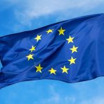 The flag of the EU European Union flutters in the wind. Churches in europe