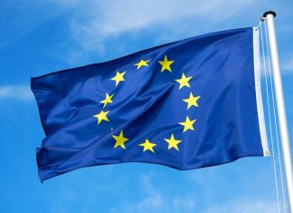 The flag of the EU European Union flutters in the wind. Churches in europe