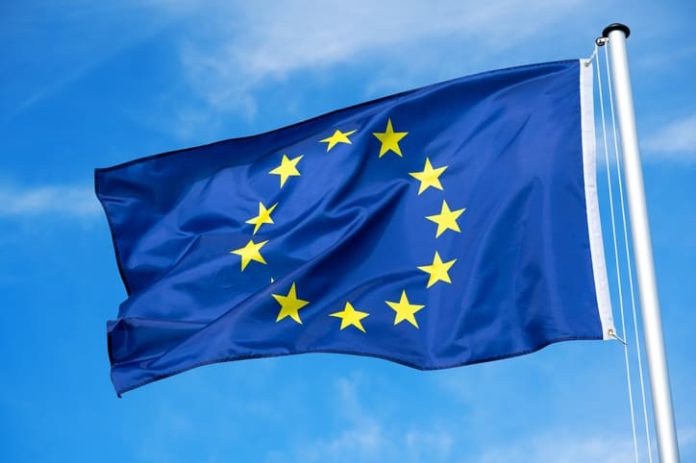 The flag of the EU European Union flutters in the wind. Churches in europe