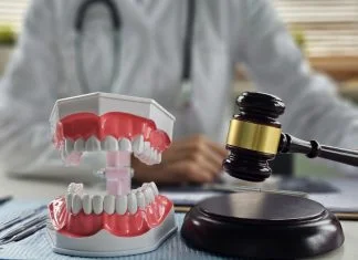 Teeth Whitening Regulations in Ireland & Europe Dental models and gavel on a desk in a professional setting related to dental law or whitening regulation
