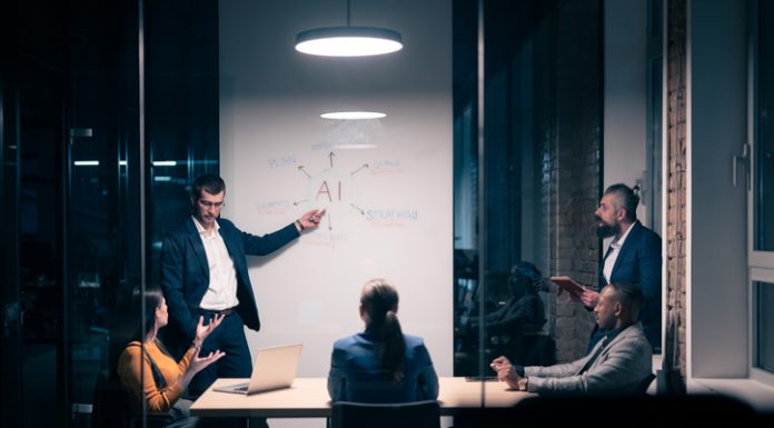 Chief AI Officer with diverse business team in modern office during a late-night meeting. Professional discussion on artificial intelligence strategy. Concept of corporate teamwork, innovation, and AI technology.