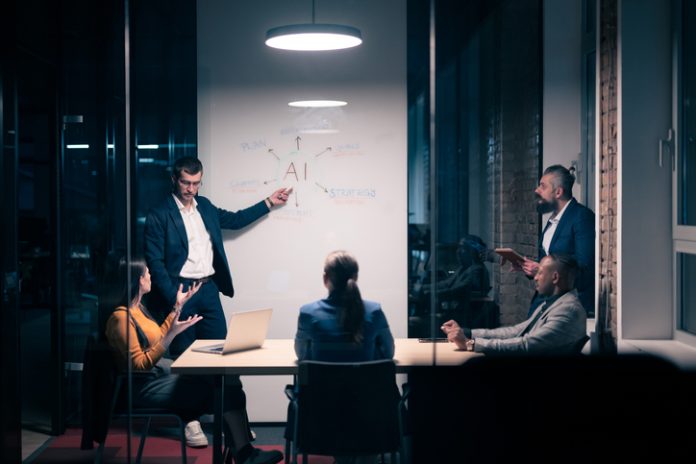 Chief AI Officer with diverse business team in modern office during a late-night meeting. Professional discussion on artificial intelligence strategy. Concept of corporate teamwork, innovation, and AI technology.