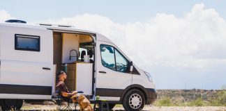 How to Plan a Campervan Cross-Country Camping Trip Without Losing Your Mind Man relaxing with dog in campervan at gorafe, spain