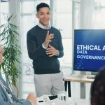 Man, presentation and screen with meeting for AI ethics, smile and planning for future web development at office. Person, speaker and staff in boardroom with data governance at startup tech agency