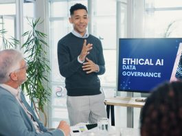 Gartner: The Leadership Blind Spot: Why Executive AI Literacy Will Shape Business Outcomes in 2025 Man, presentation and screen with meeting for AI ethics, smile and planning for future web development at office. Person, speaker and staff in boardroom with data governance at startup tech agency