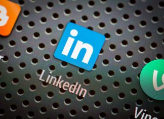 Social media icons and LinkedIn on smart phone screen.