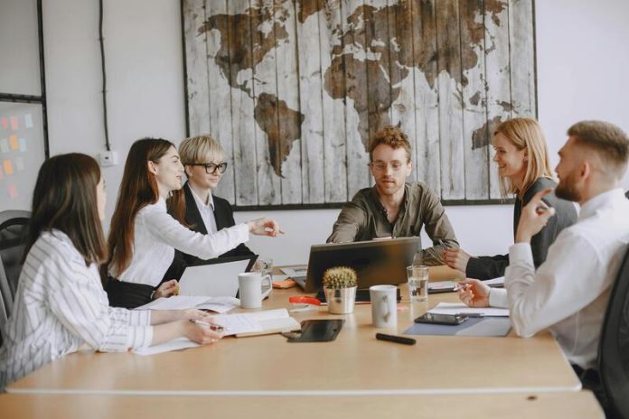 Young entrepreneurs in a modern office discussing Hong Kong company registration & digital strategies for modern startups.