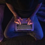 Busy man networking on laptop and cybersecurity late at night typing text working overtime