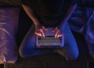 Cybersecurity in the Age of Remote Work Busy man networking on laptop and cybersecurity late at night typing text working overtime