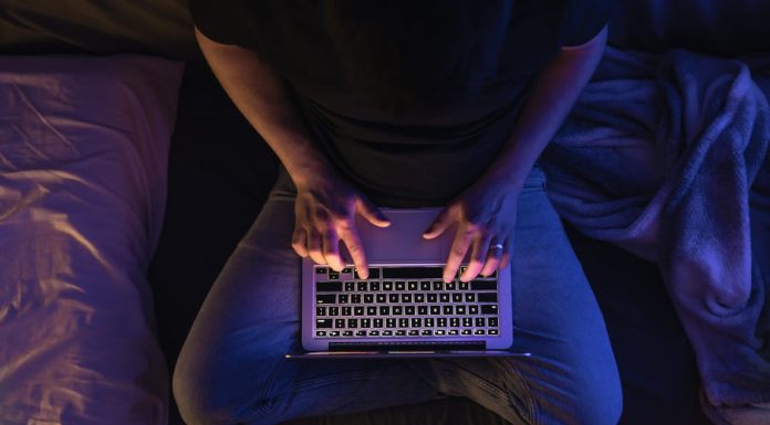 Cybersecurity in the Age of Remote Work Busy man networking on laptop and cybersecurity late at night typing text working overtime