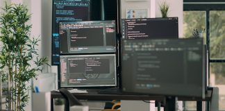 The Downstream Effects of Adopting AI for Coding, and Why Coderabbit Thinks It Can Fix Them CodeRabbit - Desk with multiple screens
