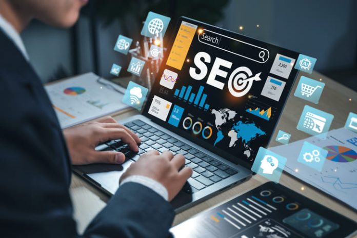 SEO text with magnifying glass and laptop, illustrating search engine optimization, web traffic analytics, keyword ranking, and online visibility improvement